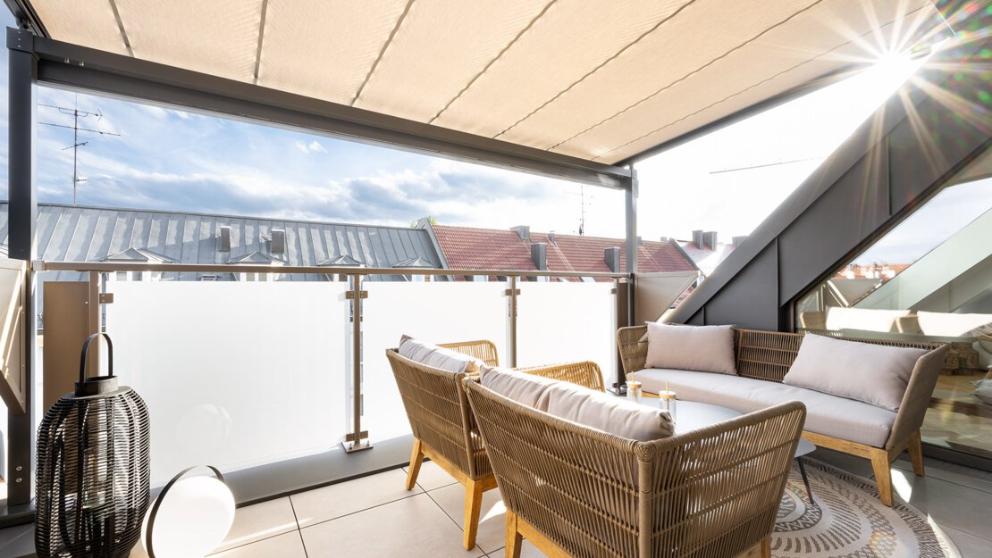 Balkon mit Sonnensegel und Loungemöbeln