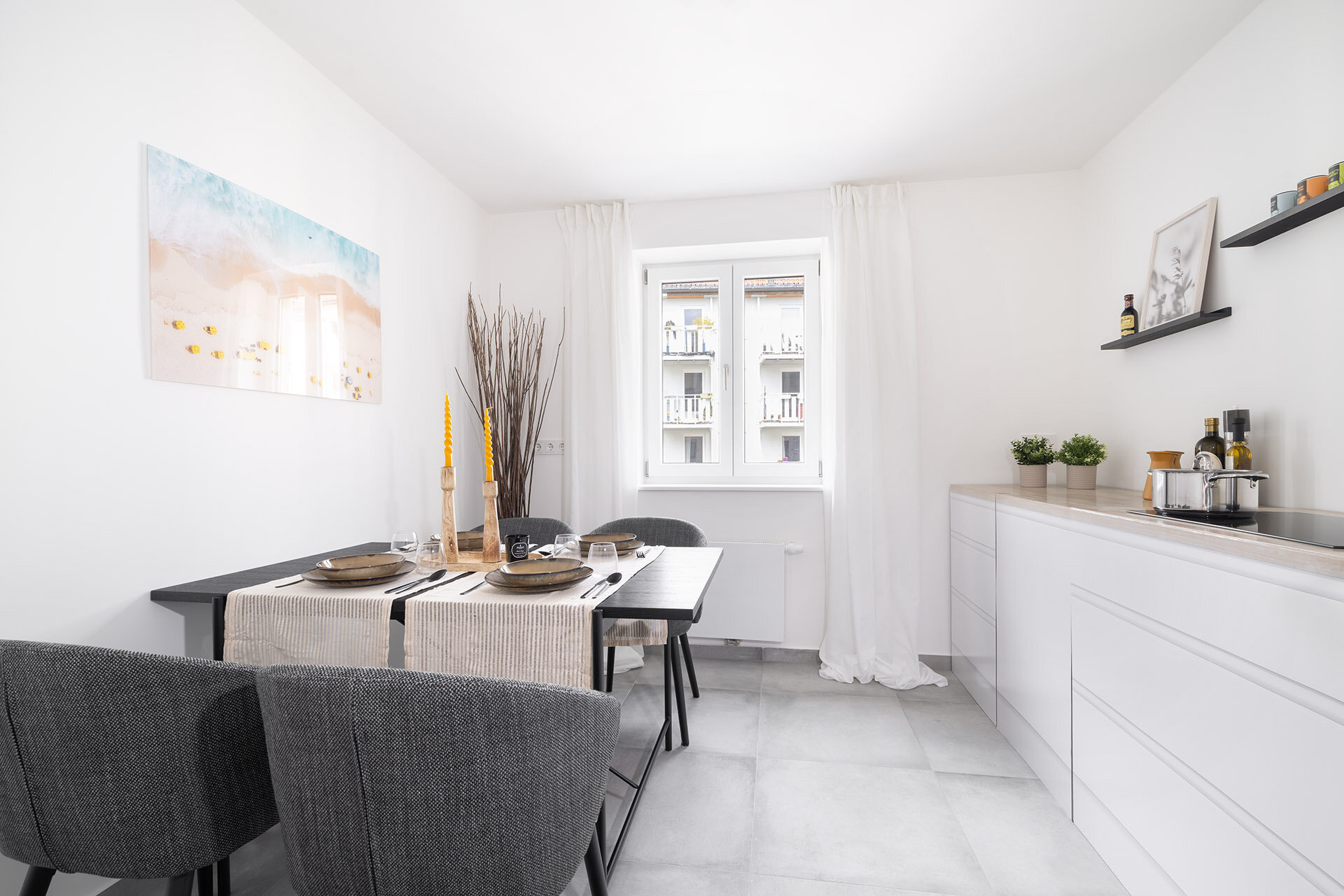 Helle Küche mit Fenster und schmaler Küchenzeile in weiß und Esstisch für vier Personen