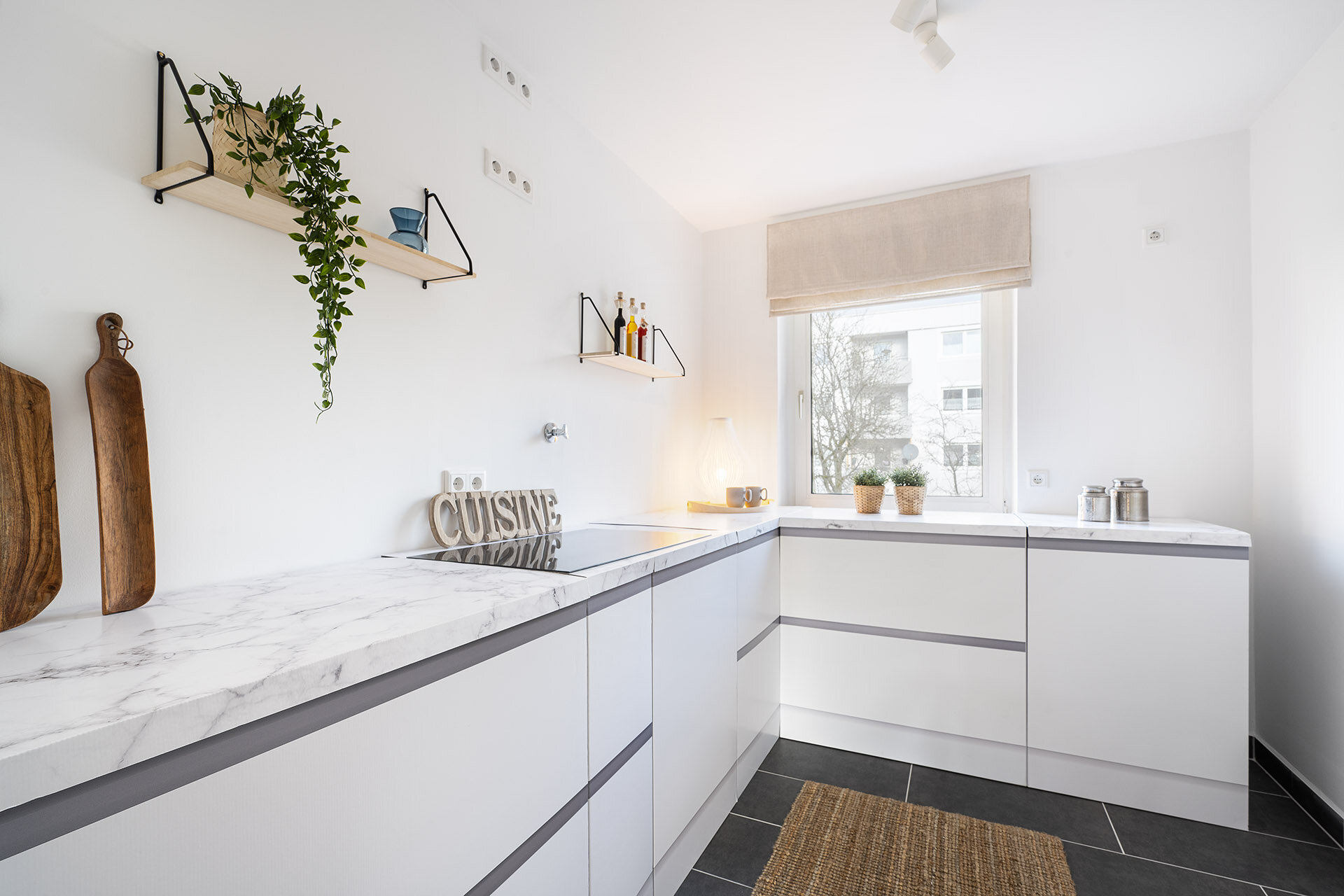 Helle schmale Küche mit Küchenzeile und kleinen Wandregalen