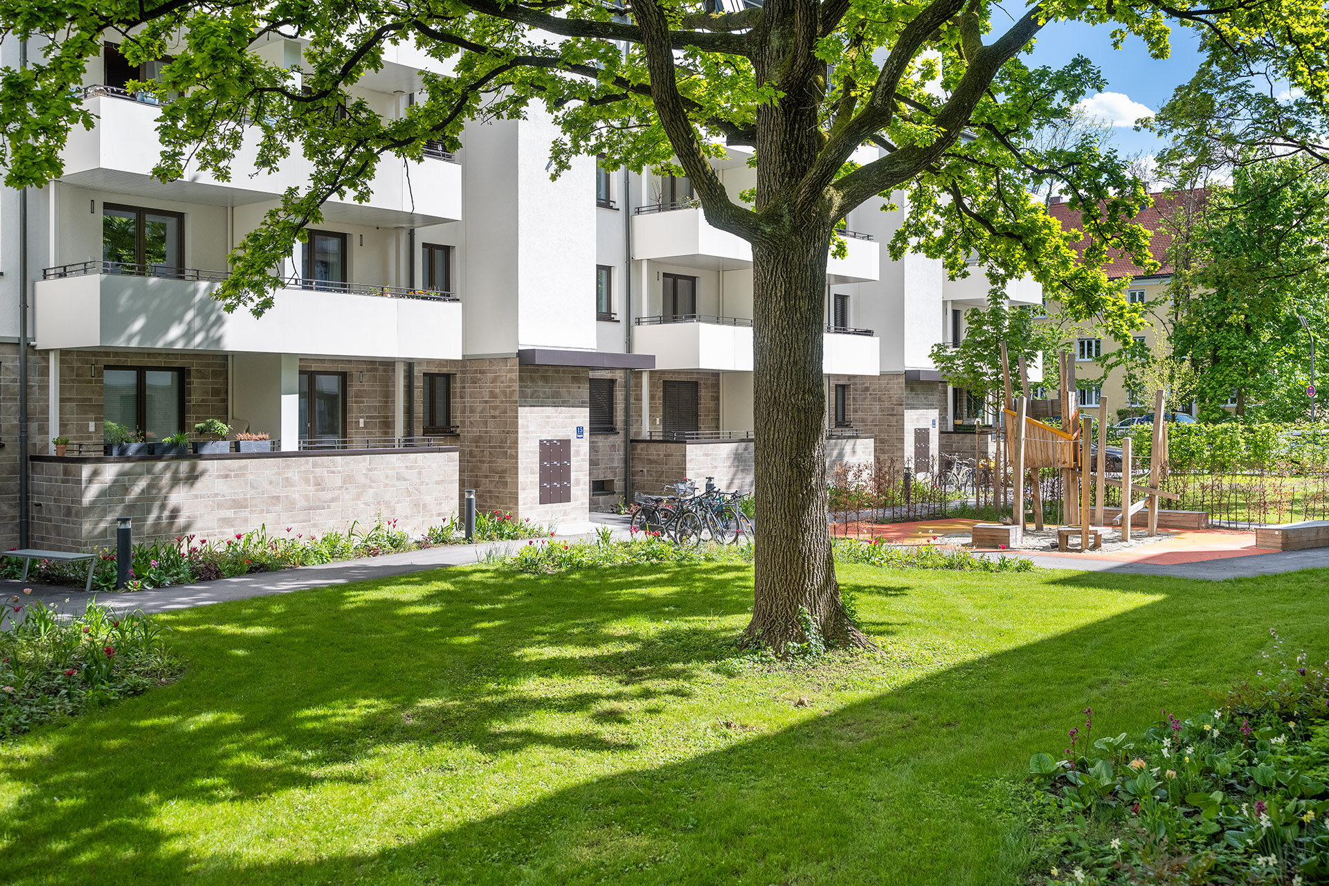Blick auf Grünanlage und Spielplatz, sowie Fahrradparkmöglichkeiten vor dem Neubau Objekt