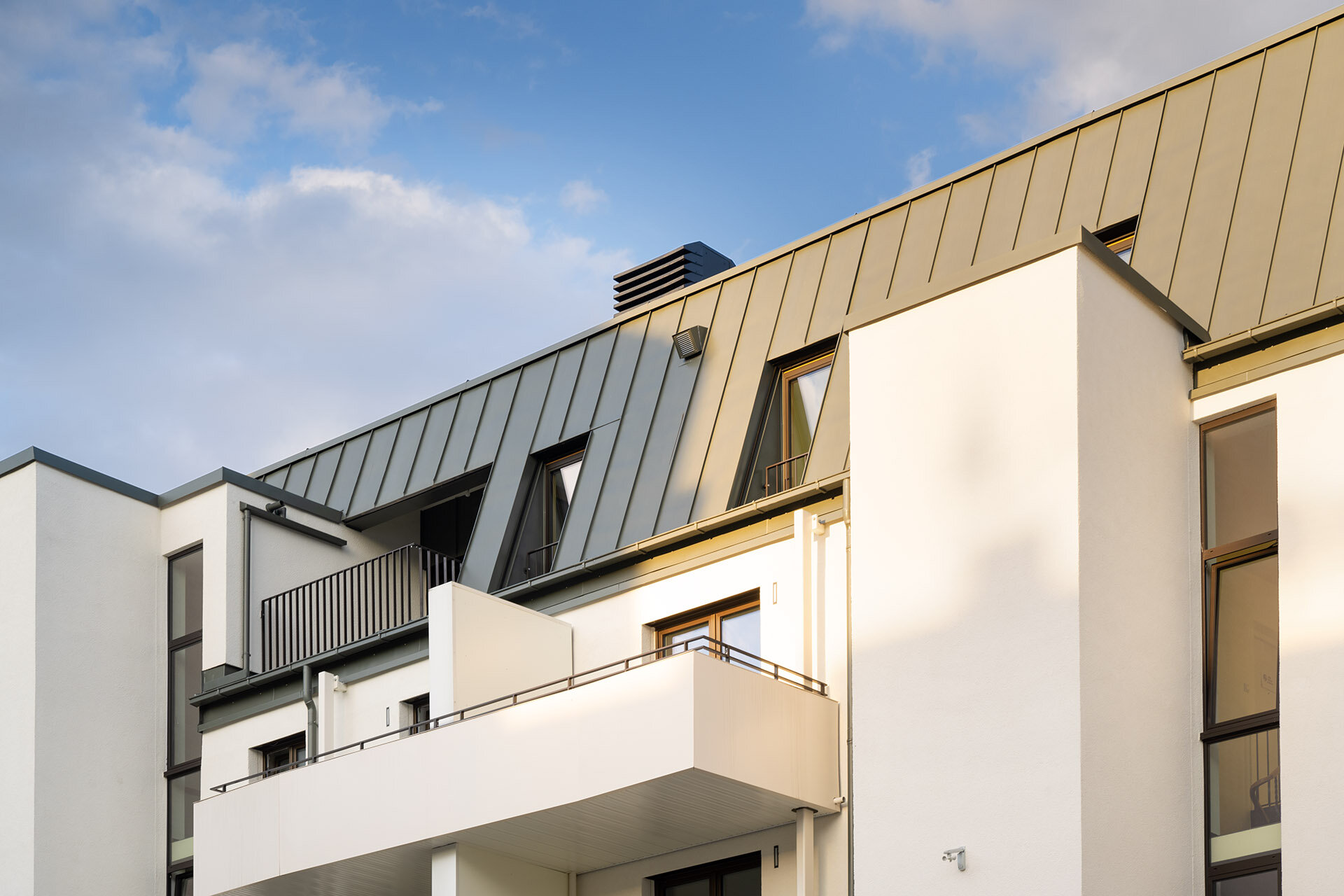 Blick von der Straße zur Dachgeschosswohnung mit Balkonen der unteren Etagen