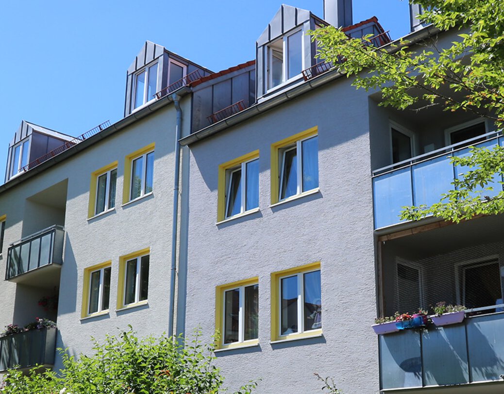 Close Up der Außenansicht des Wohnobjekts in der Ludwig-Erhard-Straße mit den obersten Wohnungen mit Balkon und Dachgeschosswohnung mit Dachgaube