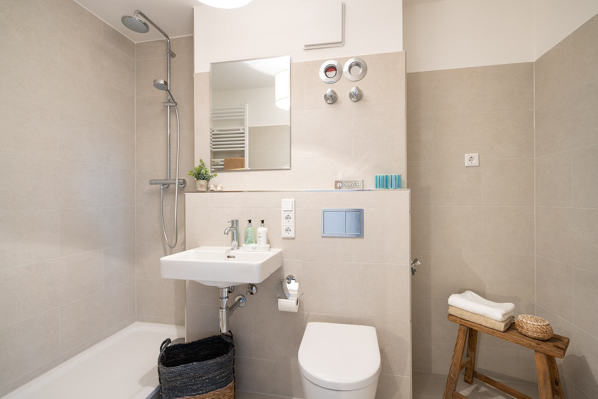 Bad mit Duschnische, Wachbecken und Toilette mit großen modernen beigen Fliesen