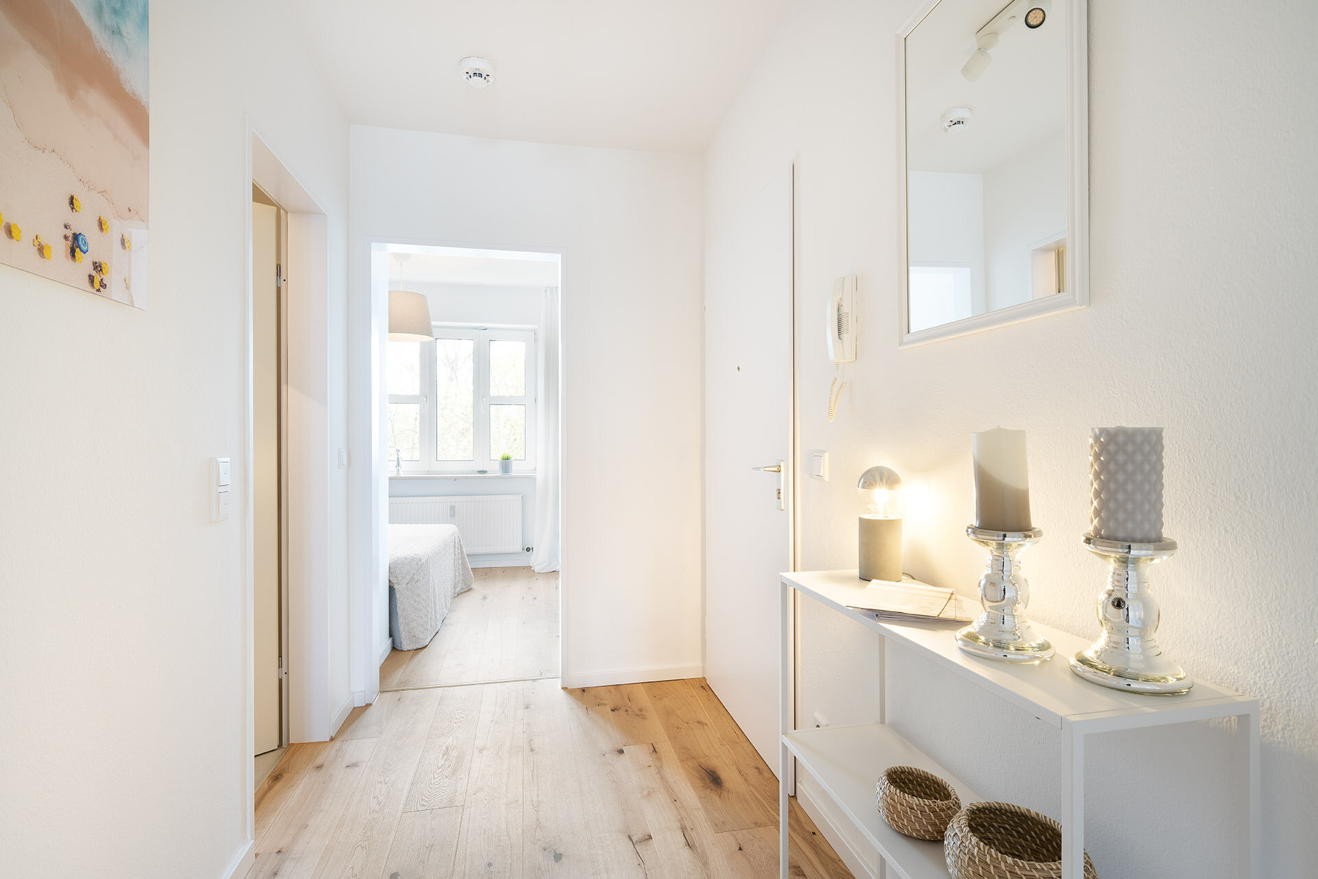 Blick auf Eingangstür und hellem freundlichen Flur mit offener Tür zum Schlafzimmer