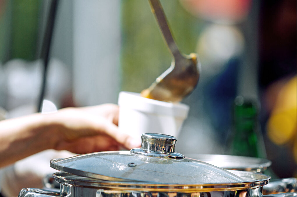 Symbolische Darstellung von Fürsorge und sozialem Engagement: Essensausgabe als Zeichen gemeinschaftlichen Handelns.