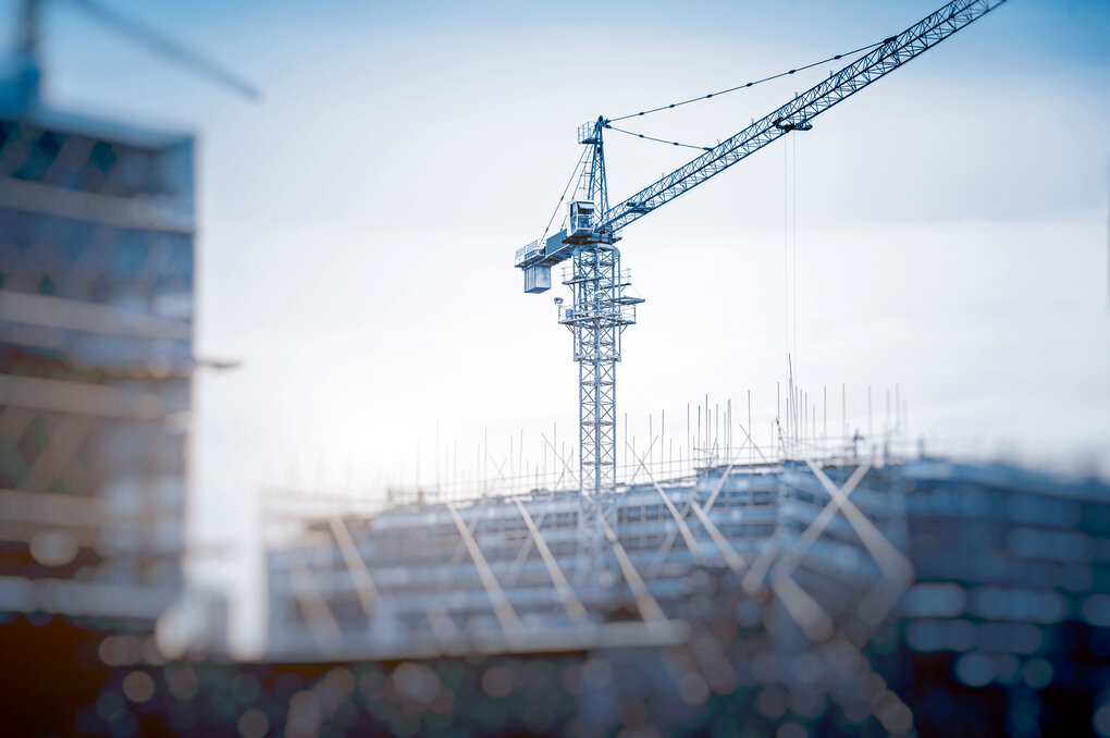Eine Baustelle mit einem Kran - symbolisiert Wachstum in weiteren Geschäftsfeldern wie Projektentwicklung, An- und Verkauf, energetische Modernisierungen